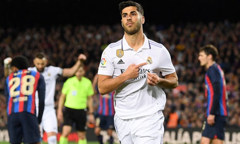 ماركو أسينسيو يحتفل بالإشارة إلى شعار ريال مدريد بعد التسجيل في شباك برشلونة (المصدر:Gettyimages)