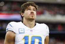 HOUSTON, TEXAS - JANUARY 11: Quarterback Justin Herbert #10 of the Los Angeles Chargers stands on the sidelines during the national anthem prior to an AFC Wild Card game against the Houston Texans, at NRG Stadium on January 11, 2025 in Houston, Texas. (